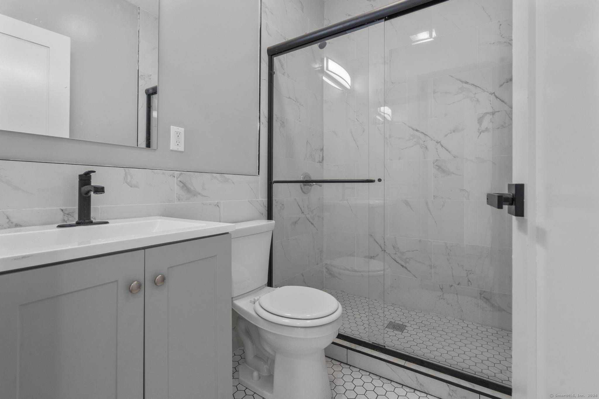 111 Bank Street, Unit 2A Waterbury, CT 06702 - Photo 11 of 16 a bathroom with a sink a toilet and shower