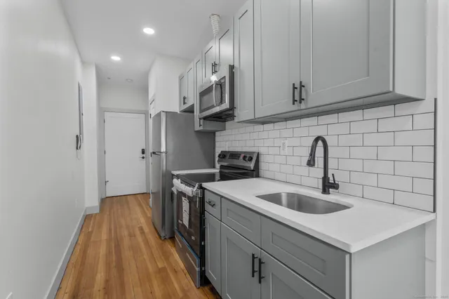 a kitchen with stainless steel appliances granite countertop a sink stove and refrigerator