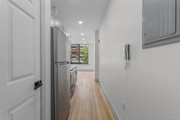 a view of a hallway with wooden floor and closet