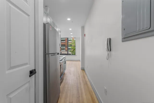 a view of a hallway with wooden floor and closet