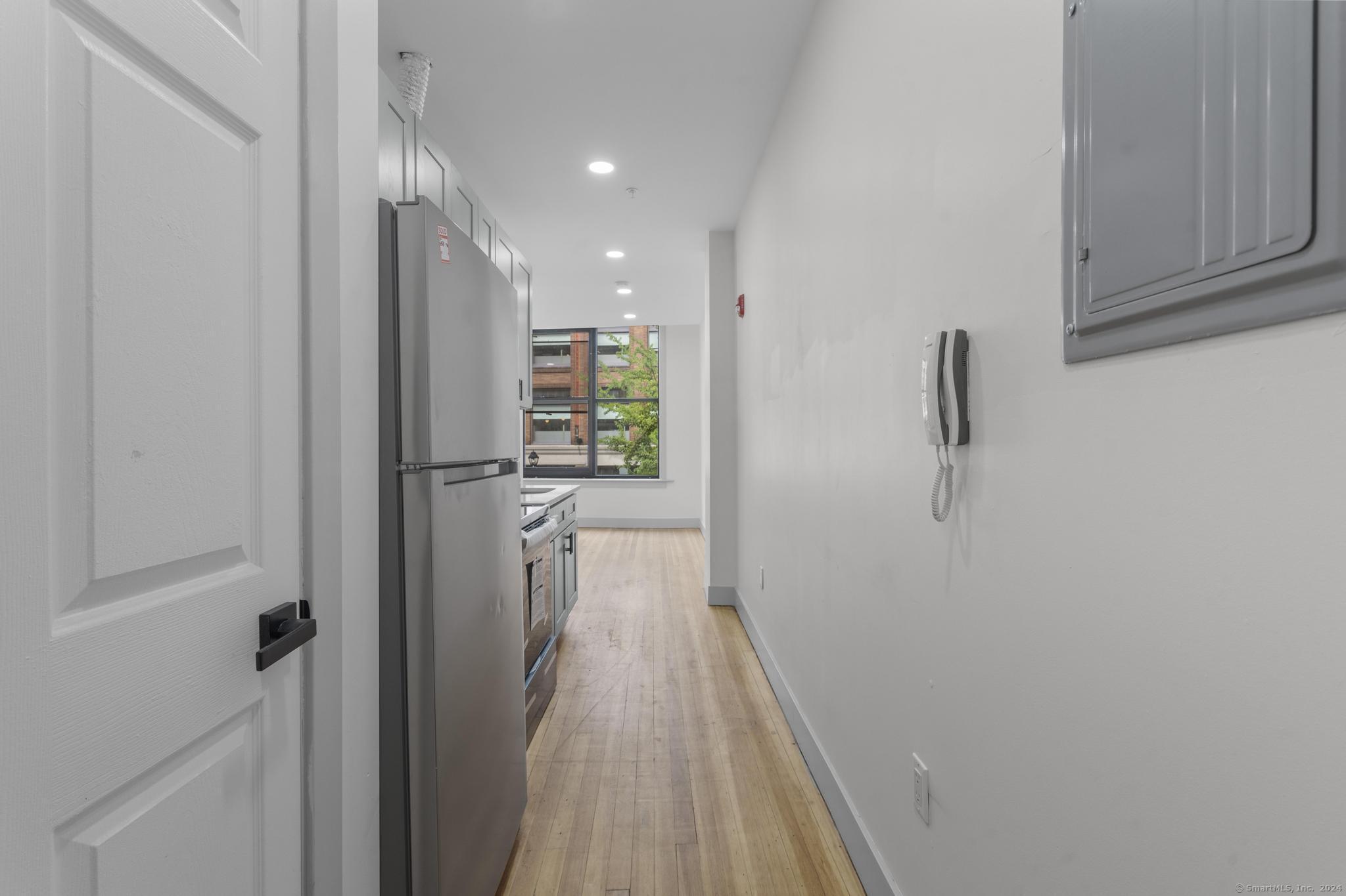 111 Bank Street, Unit 2A Waterbury, CT 06702 - Photo 4 of 16 a view of a hallway with wooden floor and closet