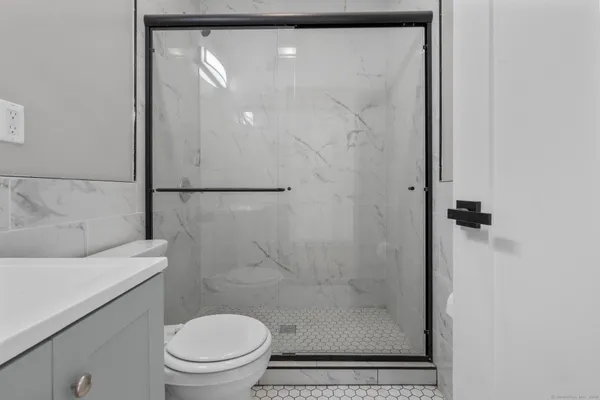 a bathroom with a shower a toilet and a sink