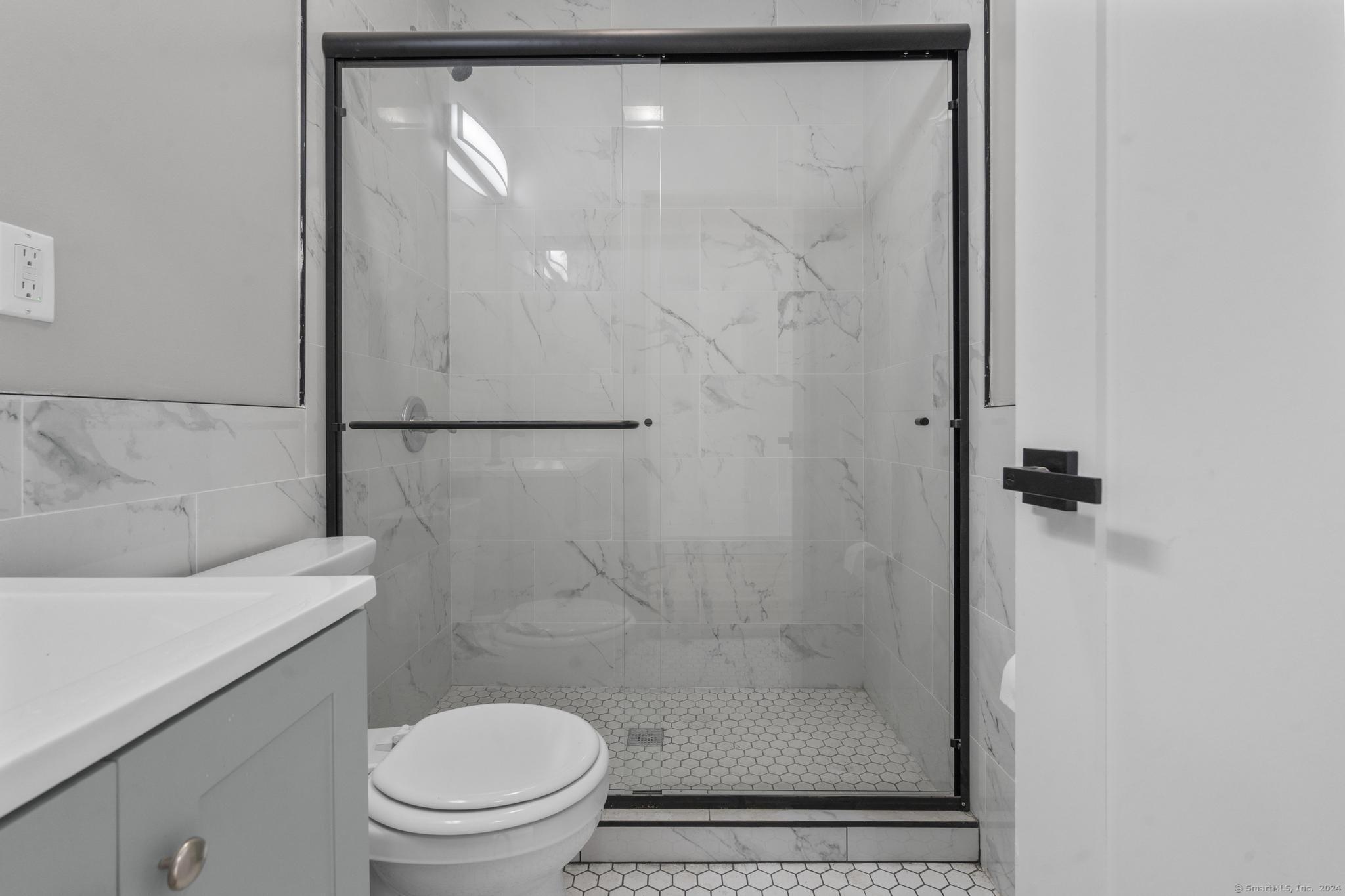 111 Bank Street, Unit 2A Waterbury, CT 06702 - Photo 10 of 16 a bathroom with a shower a toilet and a sink