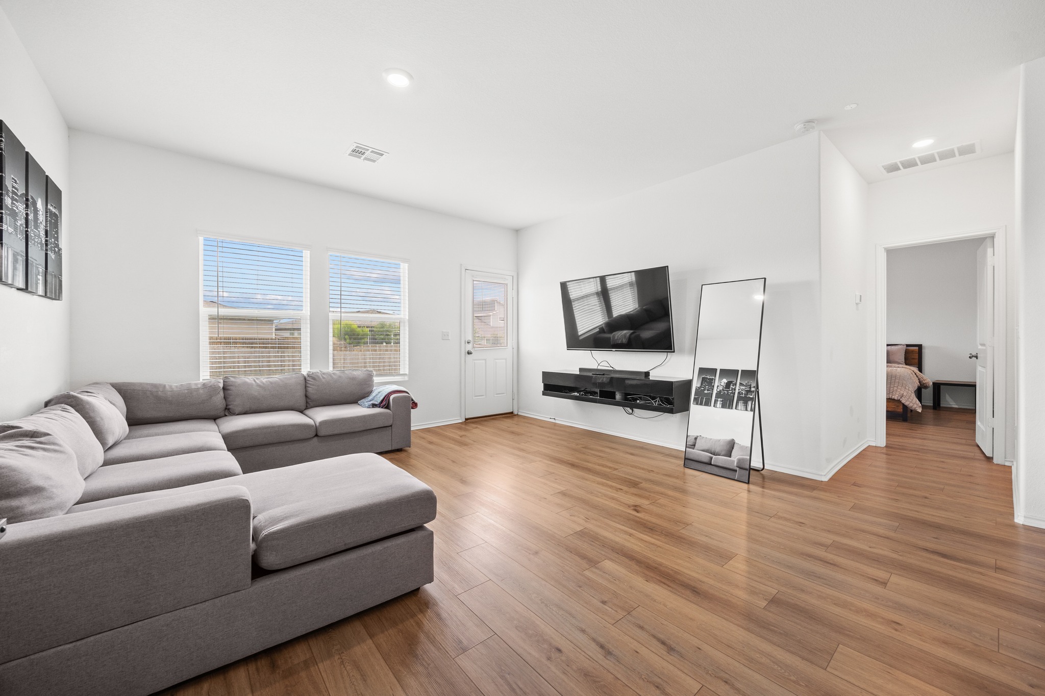 14121 Berning Road Manor, TX 78653 - Photo 2 of 27 Natural light bathes this spacious living room, featuring wood flooring and a direct exterior access door.