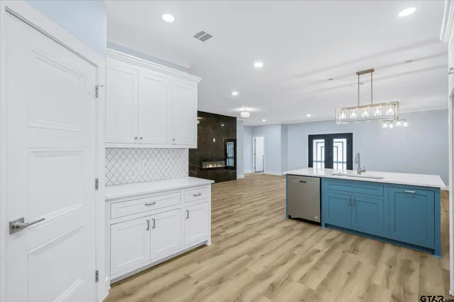 a large kitchen with granite countertop a large counter top and stainless steel appliances