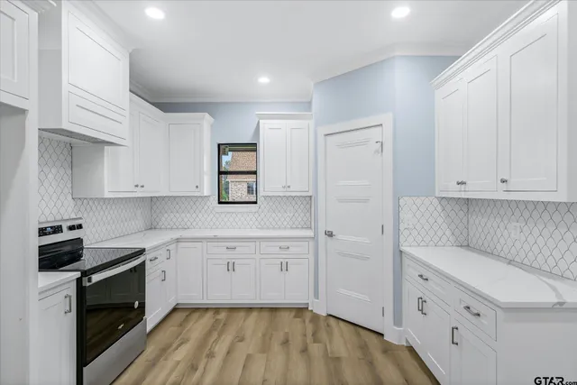 a kitchen with white cabinets and black appliances