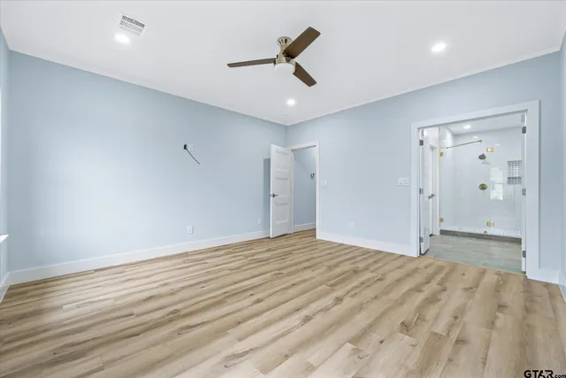 wooden floor in an empty room with a ceiling fan