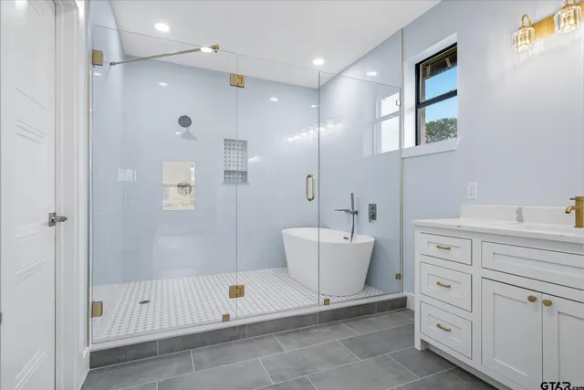 a spacious bathroom with a double vanity sink a mirror and a bathtub