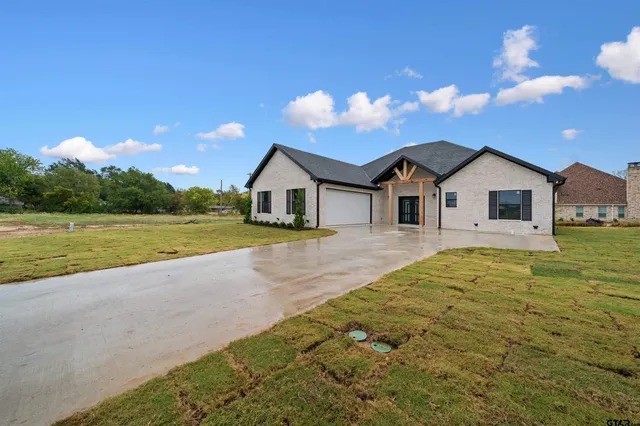 a view of a house with a yard and potted plants
