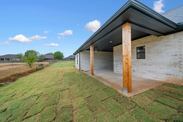 a yellow house with yard in front of it