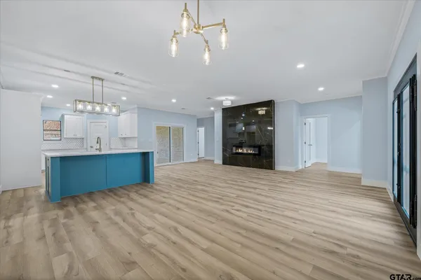 a large kitchen with kitchen island a sink dishwasher a stove and a refrigerator with wooden floor