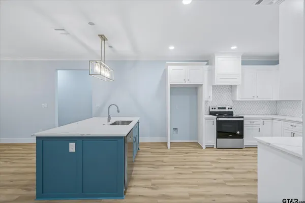 a kitchen with kitchen island a sink stainless steel appliances and cabinets