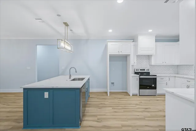 a kitchen with kitchen island a sink stainless steel appliances and cabinets