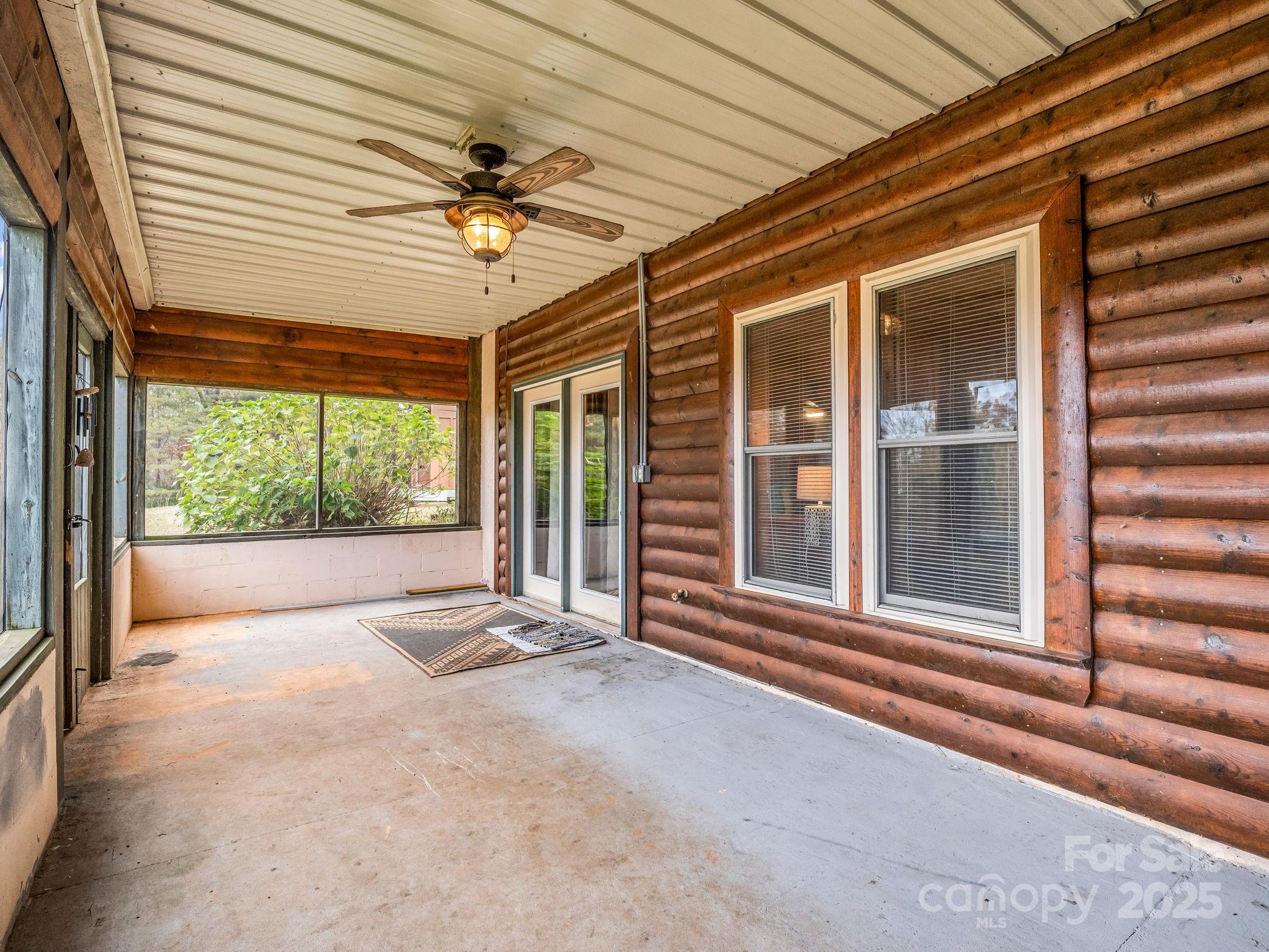 557 Emerald Parkway Rutherfordton, NC 28139 - Photo 35 of 48 a view of a patio with a table and chairs and floor to ceiling window