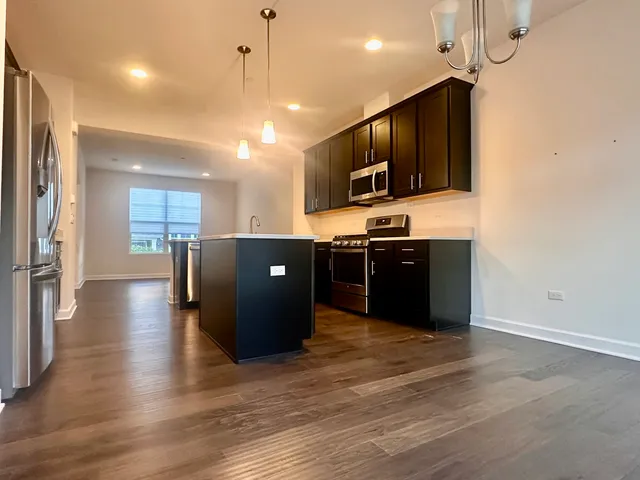 a kitchen with stainless steel appliances granite countertop a sink and a stove top oven
