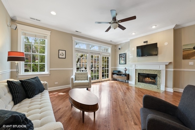 3535 North Reta Avenue, Unit 2 Chicago, IL 60657 - Photo 2 of 12 a living room with furniture a fireplace and a flat screen tv