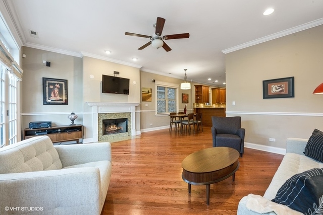 3535 North Reta Avenue, Unit 2 Chicago, IL 60657 - Photo 4 of 12 a living room with furniture a fireplace and a flat screen tv