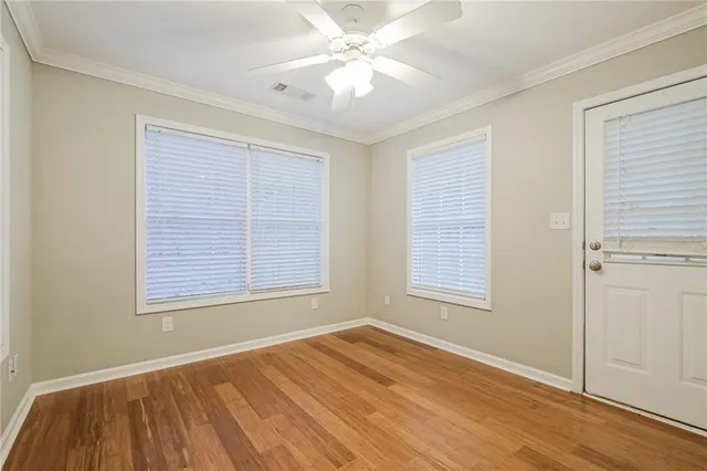 an empty room with a window and ceiling fan