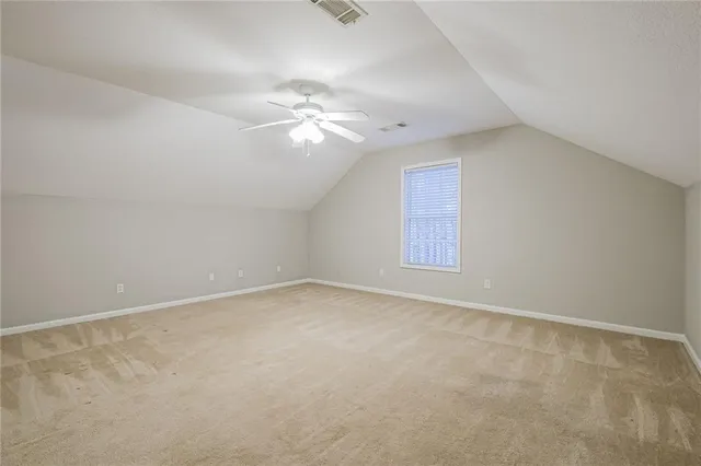 an empty room with wooden floor chandelier fan and windows