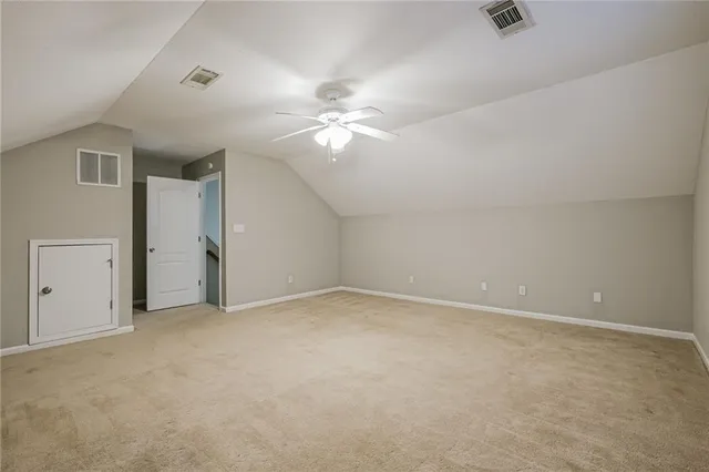 an empty room with wooden floor and ceiling fan