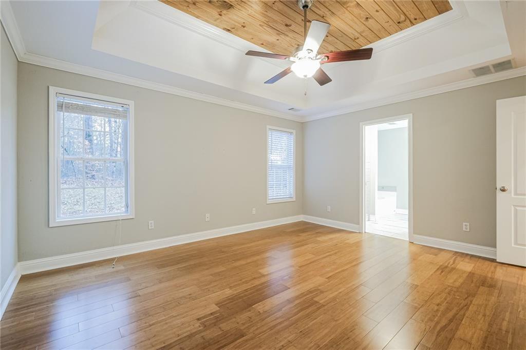 75 Pebble Crossing Covington, GA 30016 - Photo 15 of 27 an empty room with wooden floor chandelier fan and windows