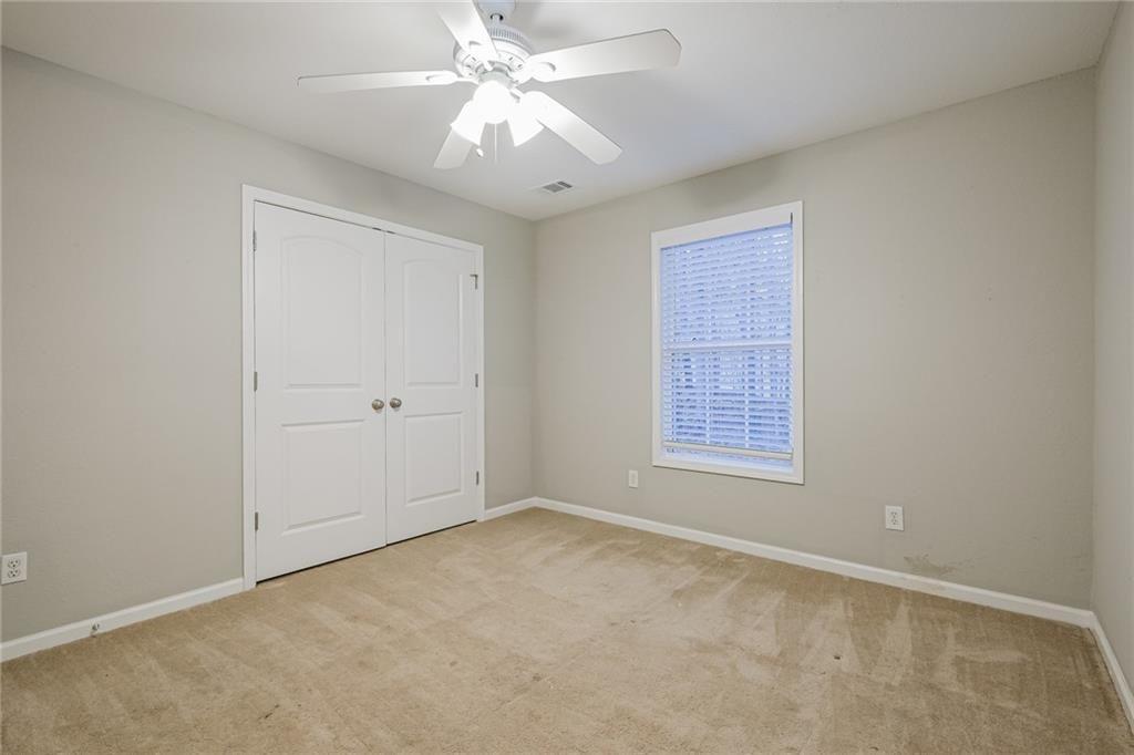 75 Pebble Crossing Covington, GA 30016 - Photo 21 of 27 an empty room with a chandelier fan and windows