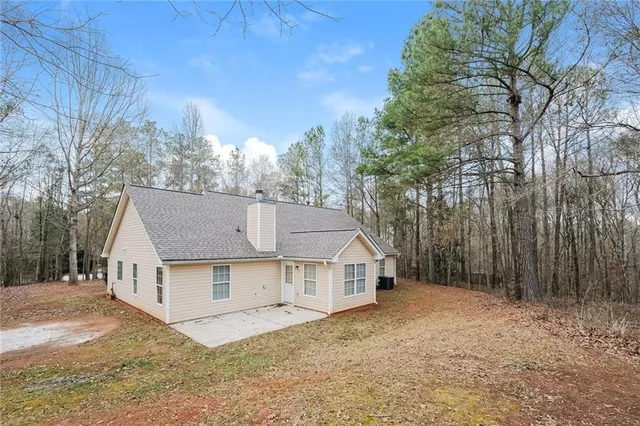 a view of a house with a yard and large tree