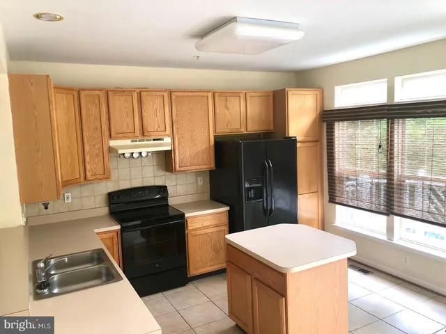 a kitchen with a stove a refrigerator and a sink