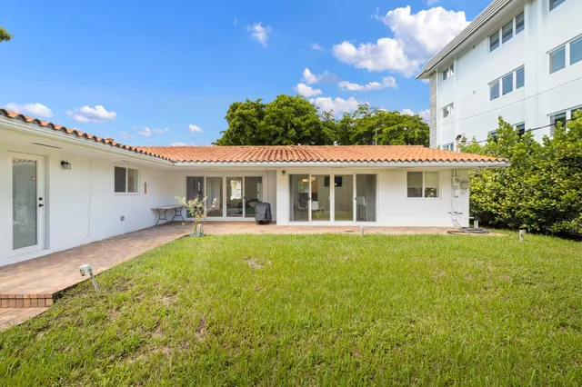 a view of a house with backyard and sitting area