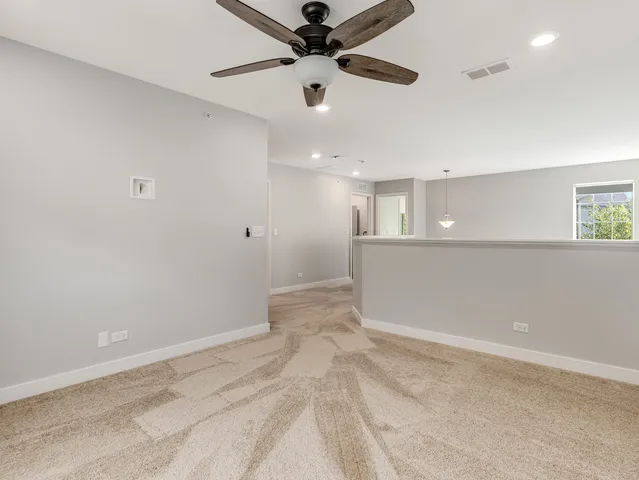an empty room with window and ceiling fan