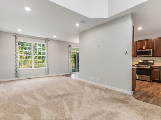 a view of a livingroom with a chandelier wooden floor and a window