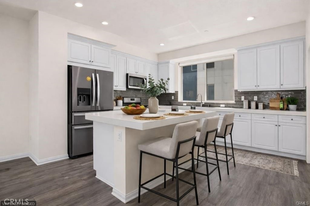 159 Steely Irvine, CA 92614 - Photo 4 of 30 Modern kitchen with quartz countertops, center island with seating, and stainless steel appliances (virtually staged).