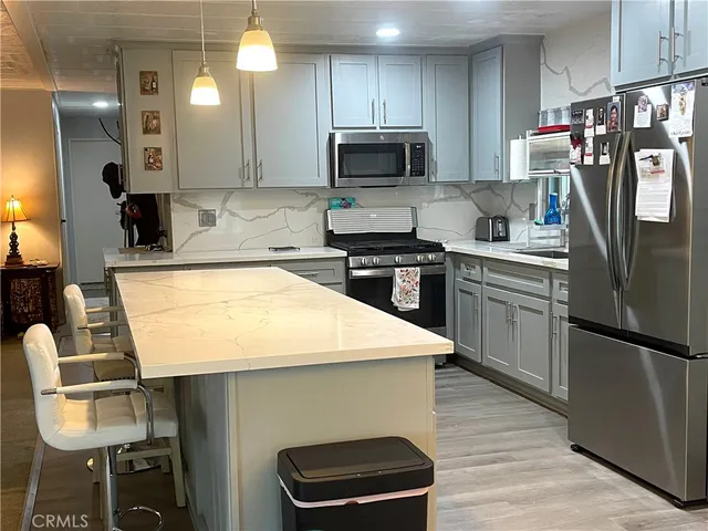 a kitchen with kitchen island a stove a sink and a refrigerator