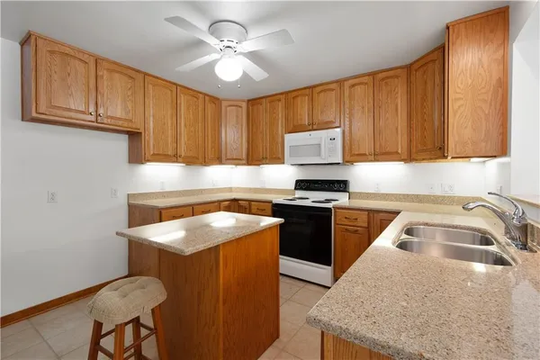 a kitchen with granite countertop a sink stove and cabinets