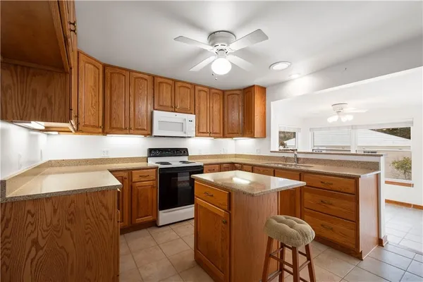 a kitchen with stainless steel appliances granite countertop a sink a stove and a refrigerator