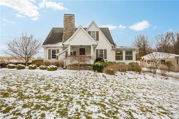 a front view of a house with a yard and trees