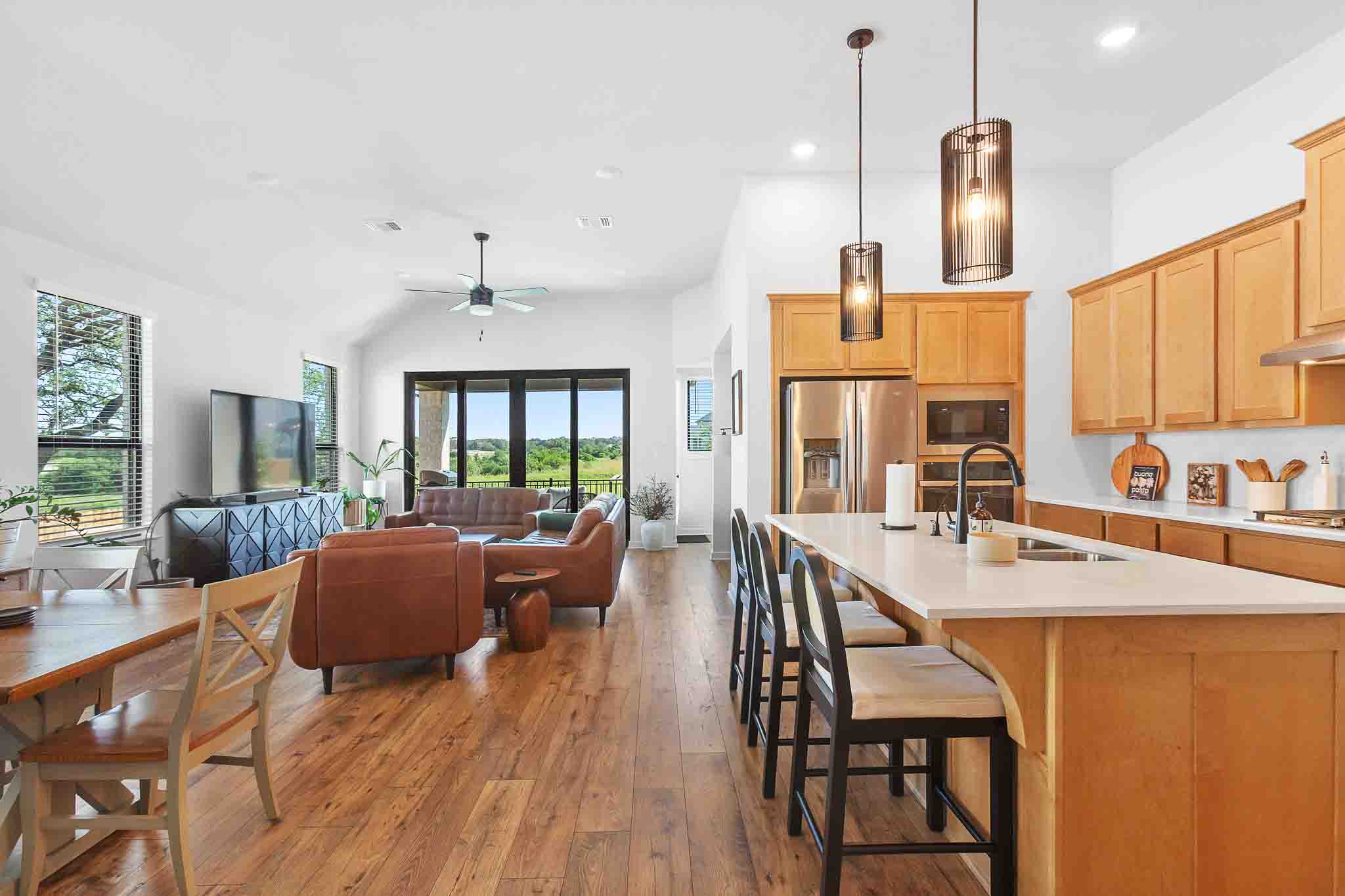 220 Basket Flower Loop Kyle, TX 78640 - Photo 2 of 40 An open-concept living space with an abundance of natural light offers seamless transitions between the kitchen, dining, and living areas.