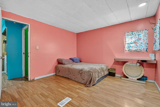 a bedroom with a bed a lamp and a large window