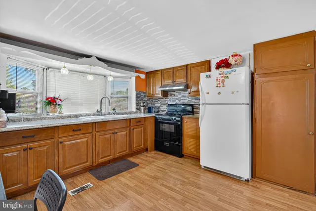 a kitchen with stainless steel appliances a refrigerator and wooden cabinets