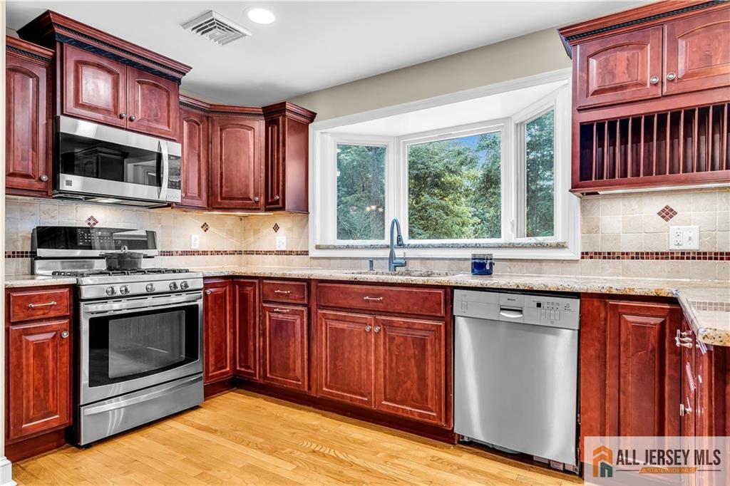 20 Oak Hills Road Edison, NJ 08820 - Photo 8 of 41 a kitchen with stainless steel appliances granite countertop a stove a sink dishwasher and a microwave oven with cabinets