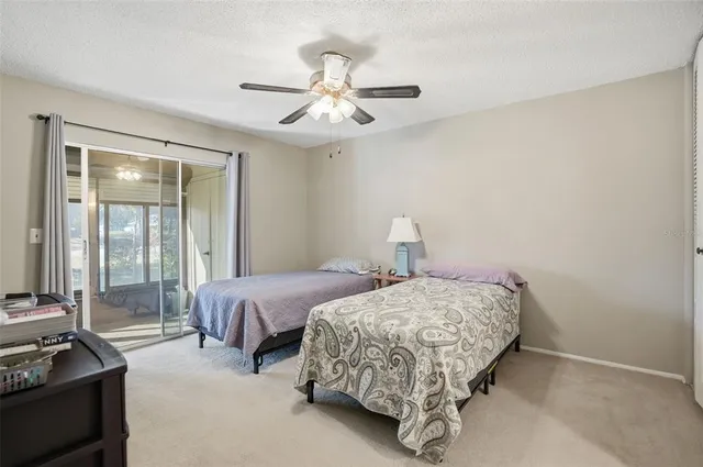 a bedroom with two beds and ceiling fan