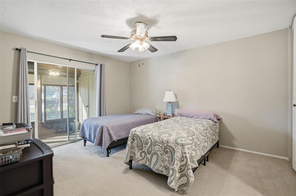 11203 Pembridge Court, Unit 1 Port Richey, FL 34668 - Photo 13 of 32 a bedroom with two beds and ceiling fan