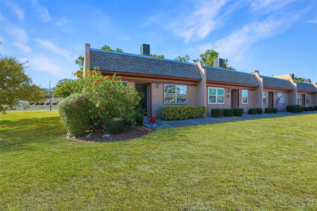 11203 Pembridge Court, Unit 1 Port Richey, FL 34668 - Photo 2 of 32 a front view of a house with a garden