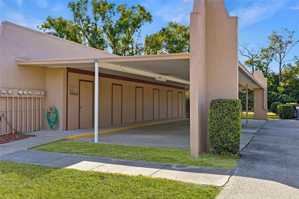 11203 Pembridge Court, Unit 1 Port Richey, FL 34668 - Photo 22 of 32 a view of a house with a small yard plants and large tree