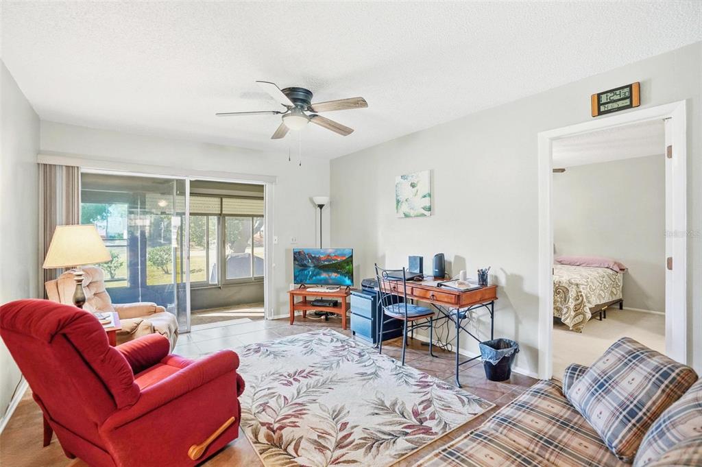 11203 Pembridge Court, Unit 1 Port Richey, FL 34668 - Photo 3 of 32 a living room with furniture a table and a large window