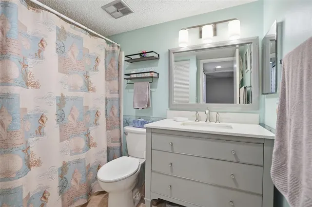 a bathroom with a granite countertop toilet sink and a mirror
