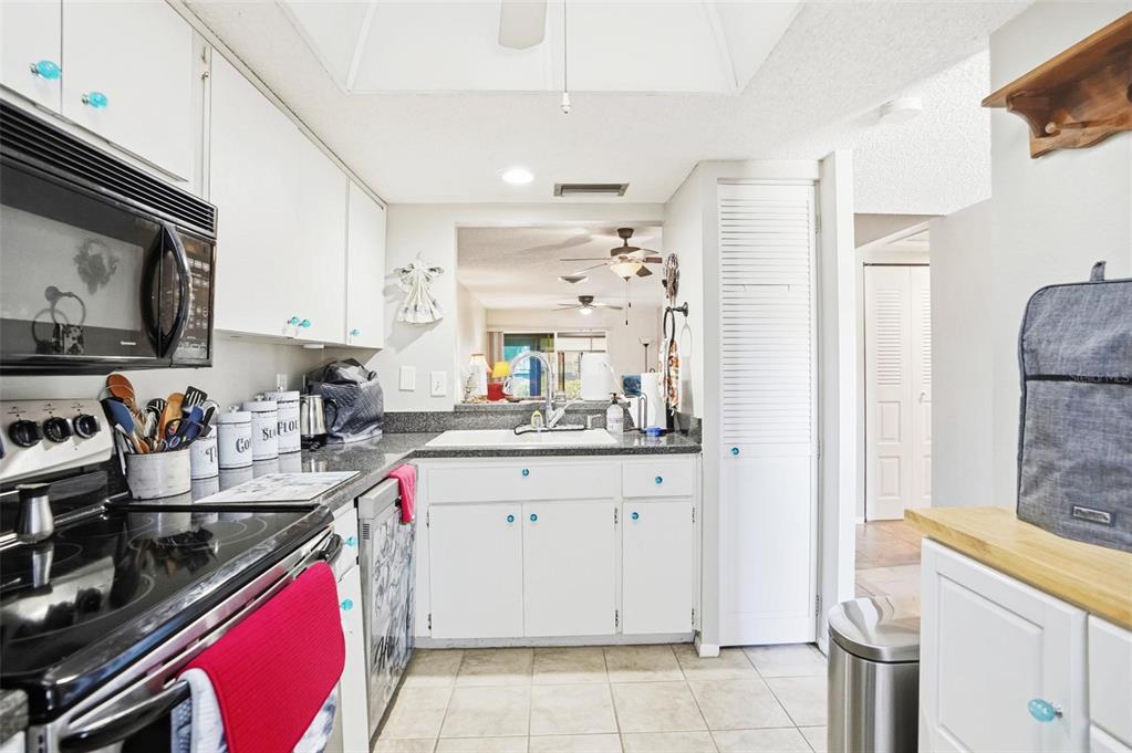 11203 Pembridge Court, Unit 1 Port Richey, FL 34668 - Photo 9 of 32 a kitchen with a sink stove and cabinets