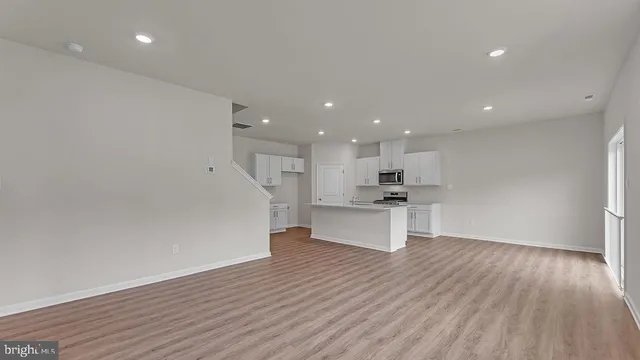 a view of kitchen with kitchen island wooden floor and center island