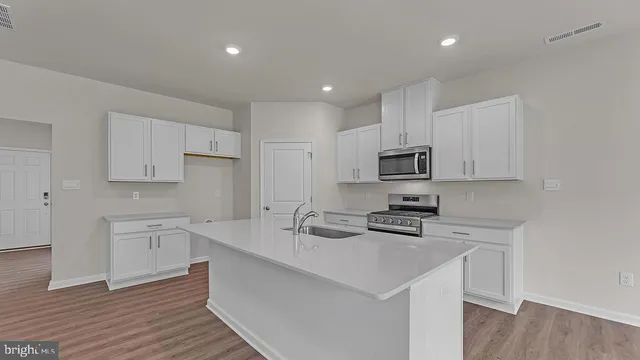 a kitchen with white cabinets stainless steel appliances and sink