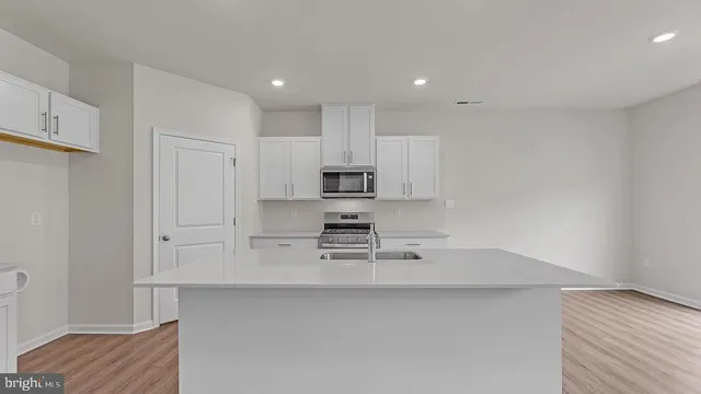 a kitchen with stainless steel appliances a sink a stove a microwave and cabinets